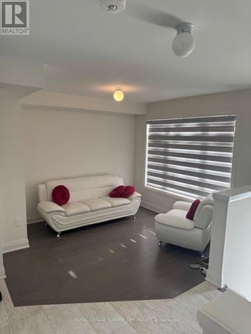 Clarington (Bowmanville) townhouse for rent - A living room with a white couch and a white chair.