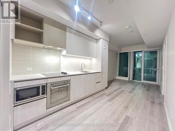 Vaughan (Vaughan Corporate Centre) condo for rent - A modern kitchen with white cabinets and stainless steel appliances.