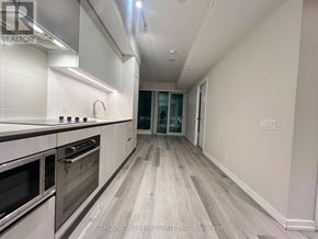 Vaughan (Vaughan Corporate Centre) condo for rent - A modern kitchen with white cabinets and stainless steel appliances.