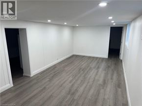 Kitchener apartment for rent - A room with wooden flooring and white walls.