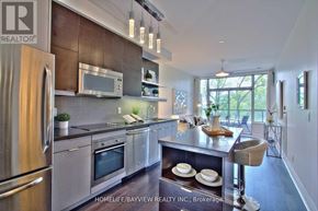 Toronto (Willowdale East) condo for rent - A modern kitchen with stainless steel appliances and a bar stool.