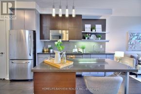 Toronto (Willowdale East) condo for rent - A modern kitchen with a wooden island and stainless steel appliances.
