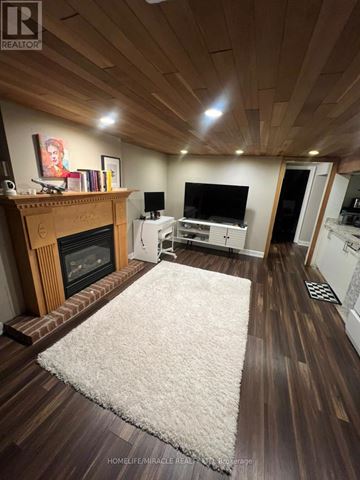 Toronto (Clairlea-Birchmount) apartment for rent - A living room with a fireplace and a rug in the middle.