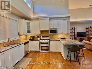 Ottawa apartment for rent - A kitchen with white cabinets and a wooden floor.