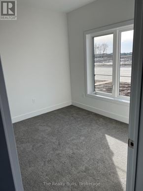 Stratford townhouse for rent - A room with a carpeted floor and a window showing a snowy landscape outside.