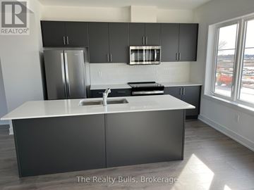 Stratford townhouse for rent - A kitchen with a white counter top and grey cabinets.