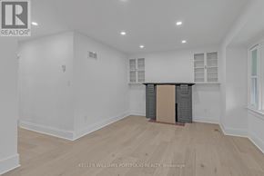 Toronto (Birchcliffe-Cliffside) apartment for rent - A spacious room with wooden flooring and white walls.