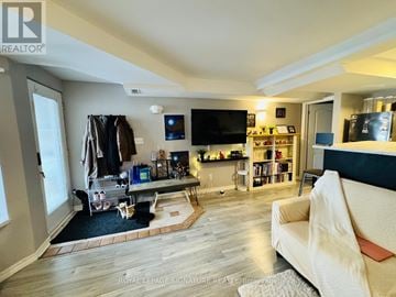 Toronto (Danforth Village-East York) apartment for rent - A living room with a white couch and a television on the wall.
