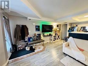 Toronto (Danforth Village-East York) apartment for rent - A living room with a couch, a TV, and a bookshelf.