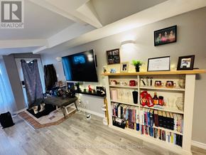 Toronto (Danforth Village-East York) apartment for rent - A living room with a TV, a dog bed, and a bookshelf.