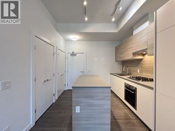Coquitlam apartment for rent - A modern kitchen with white cabinets and a wooden island.