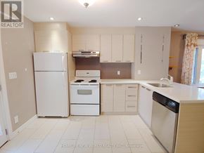 Toronto (Woodbine Corridor) apartment for rent - A kitchen with white appliances and cabinets.