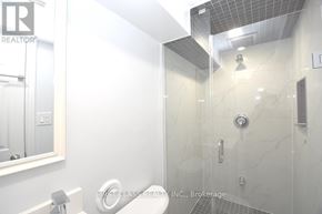 Toronto (Willowdale West) apartment for rent - A white bathroom with a glass shower stall and a mirror above the sink.