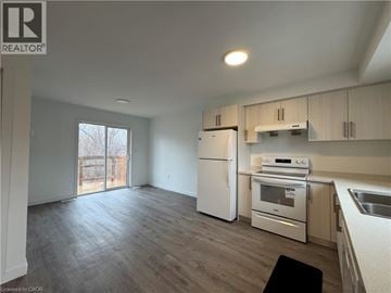 Welland townhouse for rent - A kitchen with white appliances and wooden cabinets.
