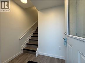 Welland townhouse for rent - A hallway with a staircase and a door.