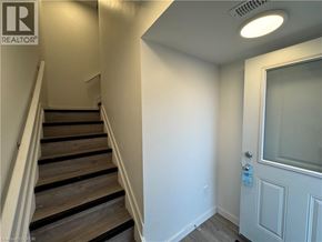 Welland townhouse for rent - A staircase with a white door at the bottom.