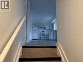 Welland townhouse for rent - A hallway with a staircase leading to a kitchen area.