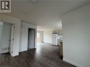 Welland townhouse for rent - A spacious room with a kitchenette and a door leading to another room.