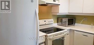 Toronto (Banbury-Don Mills) condo for rent - A kitchen with a white refrigerator and a white stove top oven.