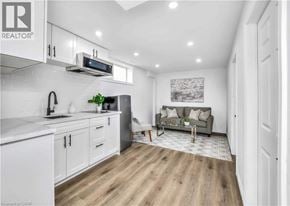 Waterloo apartment for rent - A well-lit kitchen with white cabinets and a grey sofa in the living room.