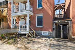 Ottawa apartment for rent - A red brick building with a white balcony and a black gate.