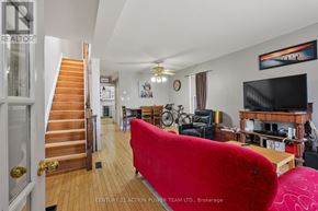 Ottawa apartment for rent - A living room with a red couch and a staircase.