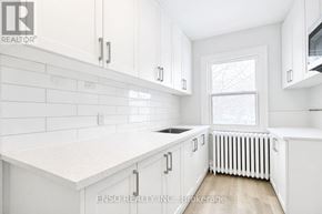 Niagara Falls (Cherrywood) multi-family for rent - A white kitchen with a window and a radiator.