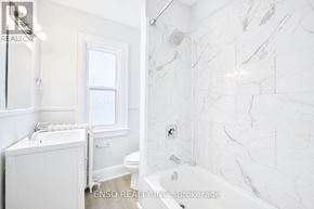 Niagara Falls (Cherrywood) multi-family for rent - A white bathroom with a marble tile wall.