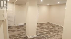 Toronto (Mount Dennis) townhouse for rent - A room with a wooden floor and white walls.