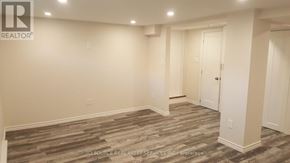 Toronto (Mount Dennis) townhouse for rent - A room with a wooden floor and white walls.