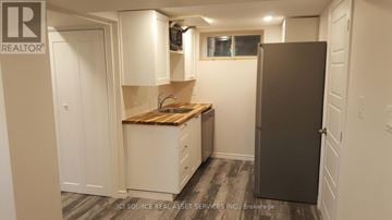 Toronto (Mount Dennis) townhouse for rent - A small kitchen with a wooden countertop and a refrigerator.