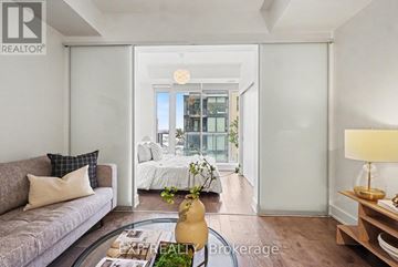 Ottawa condo for rent - A living room with a grey couch and a coffee table in front of a sliding glass door.