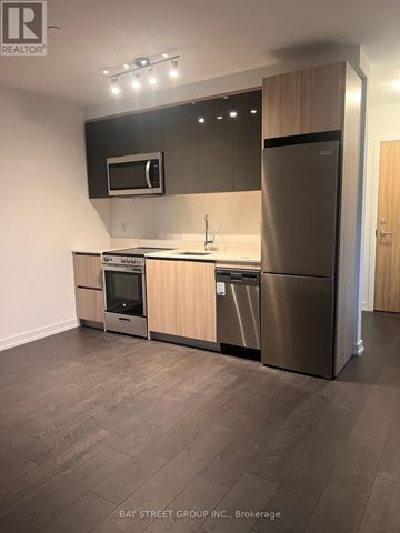 Toronto (Downsview-Roding-Cfb) condo for rent - A modern kitchen with stainless steel appliances and wooden cabinets.