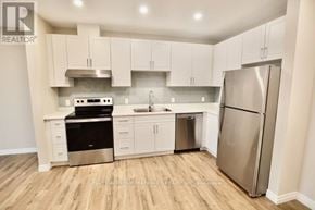 Dutton/Dunwich (Dutton) house for rent - A kitchen with white cabinets and a stainless steel refrigerator.
