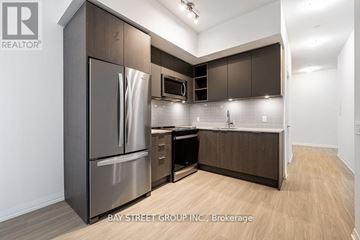 Toronto (Mount Pleasant East) condo for rent - A modern kitchen with dark wood cabinets and stainless steel appliances.