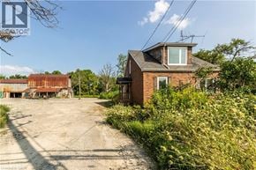 Glanbrook apartment for rent - A house with a red roof is surrounded by greenery and a dirt road.