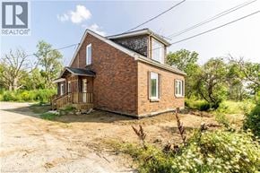 Glanbrook apartment for rent - A brick house with a balcony is surrounded by greenery.