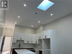 Fort Erie (Central) apartment for rent - A modern kitchen with white cabinets and a skylight.