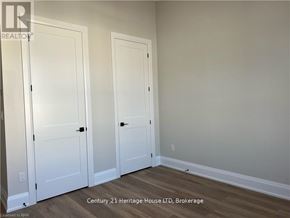 Fort Erie (Central) apartment for rent - Two white doors in a room with wooden flooring.