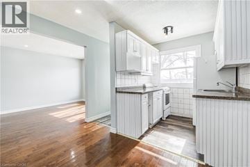 Cambridge townhouse for rent - A kitchen with white cabinets and a wooden floor.