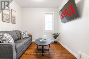 London South (South L) apartment for rent - A living room with a grey couch, a black coffee table, a plant, and a Netflix sign on the wall.