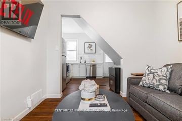 London South (South L) apartment for rent - A living room with a grey couch and a coffee table in front of a staircase.