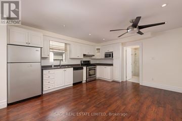 Toronto (Keelesdale-Eglinton West) duplex for rent - A well-lit kitchen with white cabinets and a wooden floor.