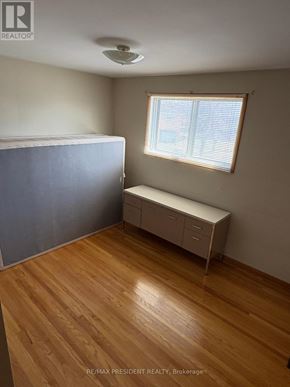 Mississauga (Malton) apartment for rent - A bedroom with a bed, a bench, and a window.