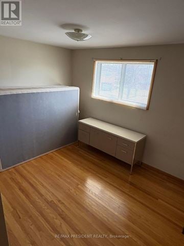 Mississauga (Malton) apartment for rent - A bedroom with a bed, a bench, and a window.