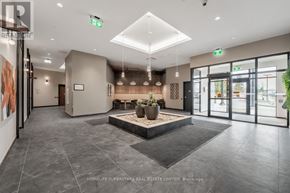 Kitchener condo for rent - A spacious lobby with a large planter in the center and a reception desk to the left.