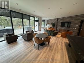 Kitchener condo for rent - A living room with a wooden floor and a large window.