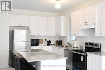 Pickering apartment for rent - A kitchen with white cabinets and a black stove top oven.