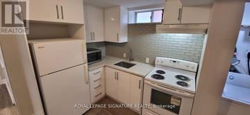 Kitchener apartment for rent - A white kitchen with a stove top oven and a microwave.