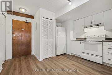 Ottawa multi-family for rent - A kitchen with white cabinets and a wooden door.